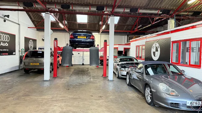 Cars raised on two-post ramps inside the EE Motors workshop in Northampton